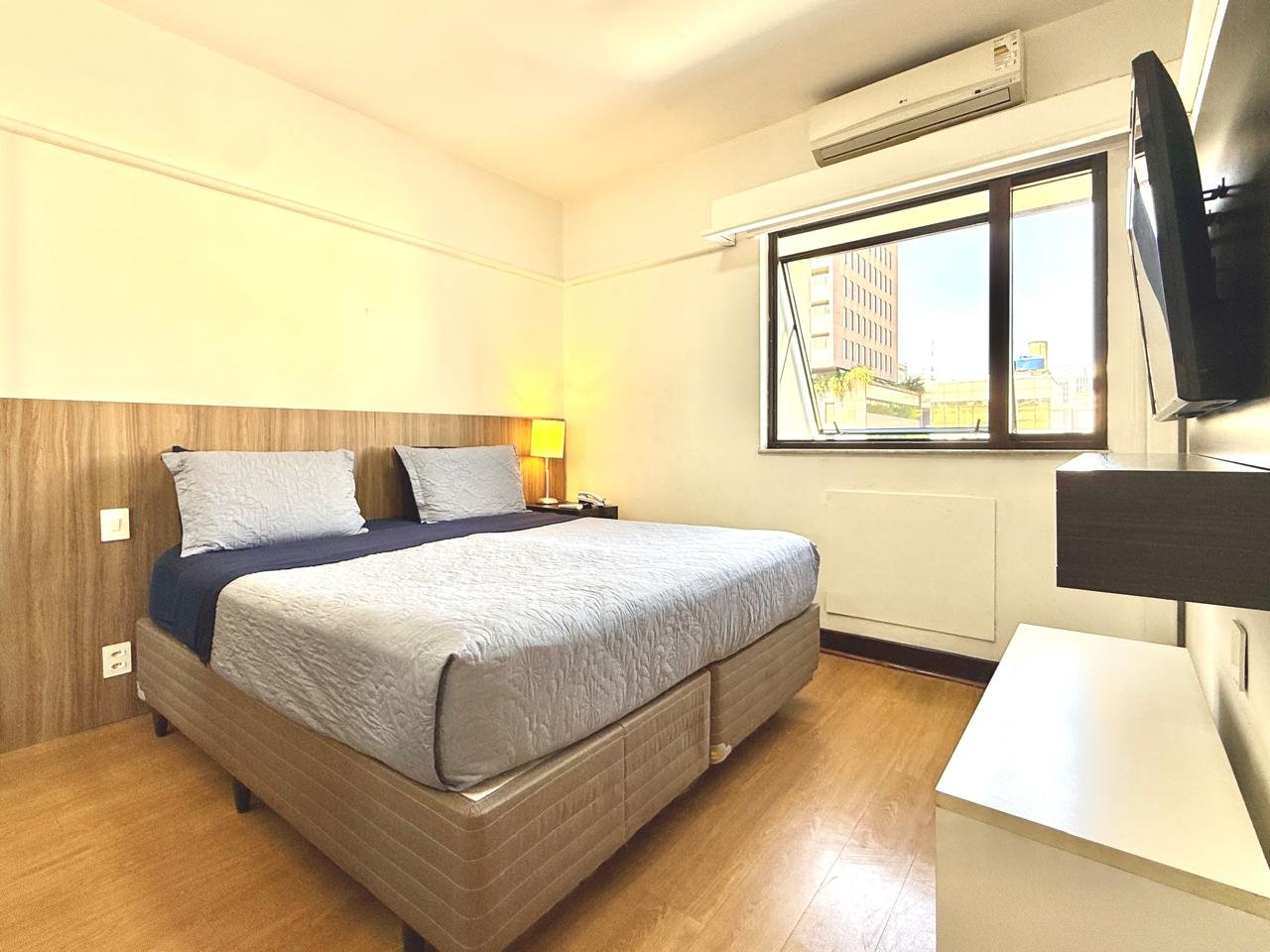 Quarto executivo com cama de casal, TV e ar-condicionado