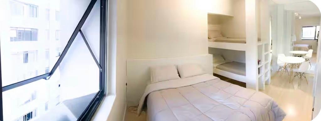 Cama de casal e beliche junto à janela