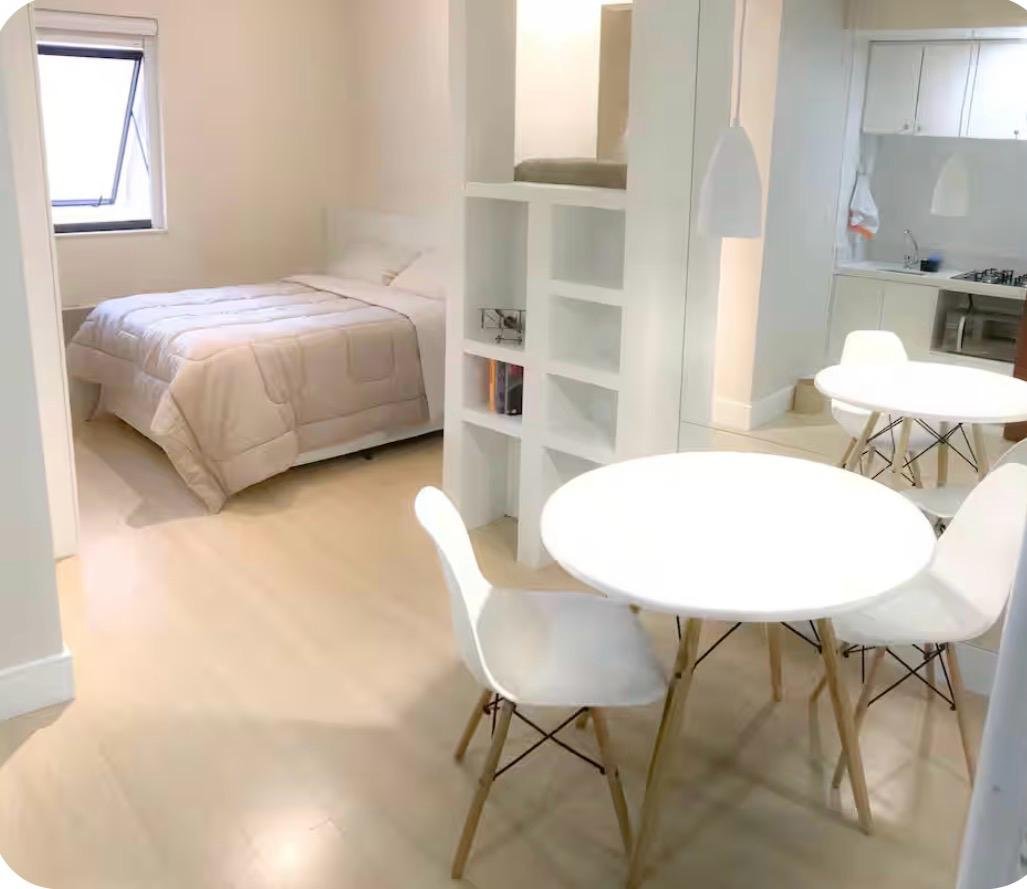 Studio integrado com cama, mesa de refeições e cozinha